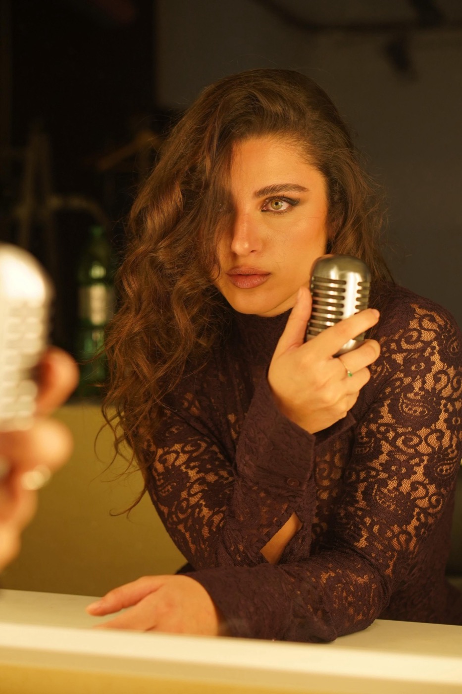 Cantante in abito di pizzo con microfono vintage