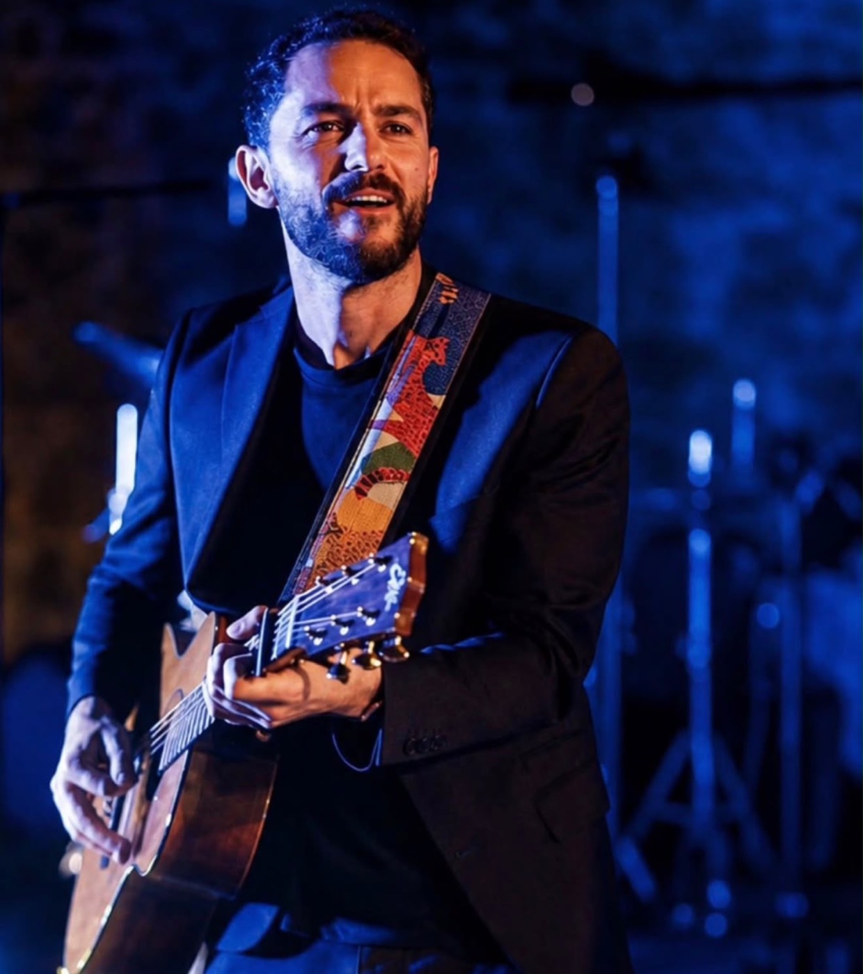 Chitarrista e cantante sul palco illuminato di blu