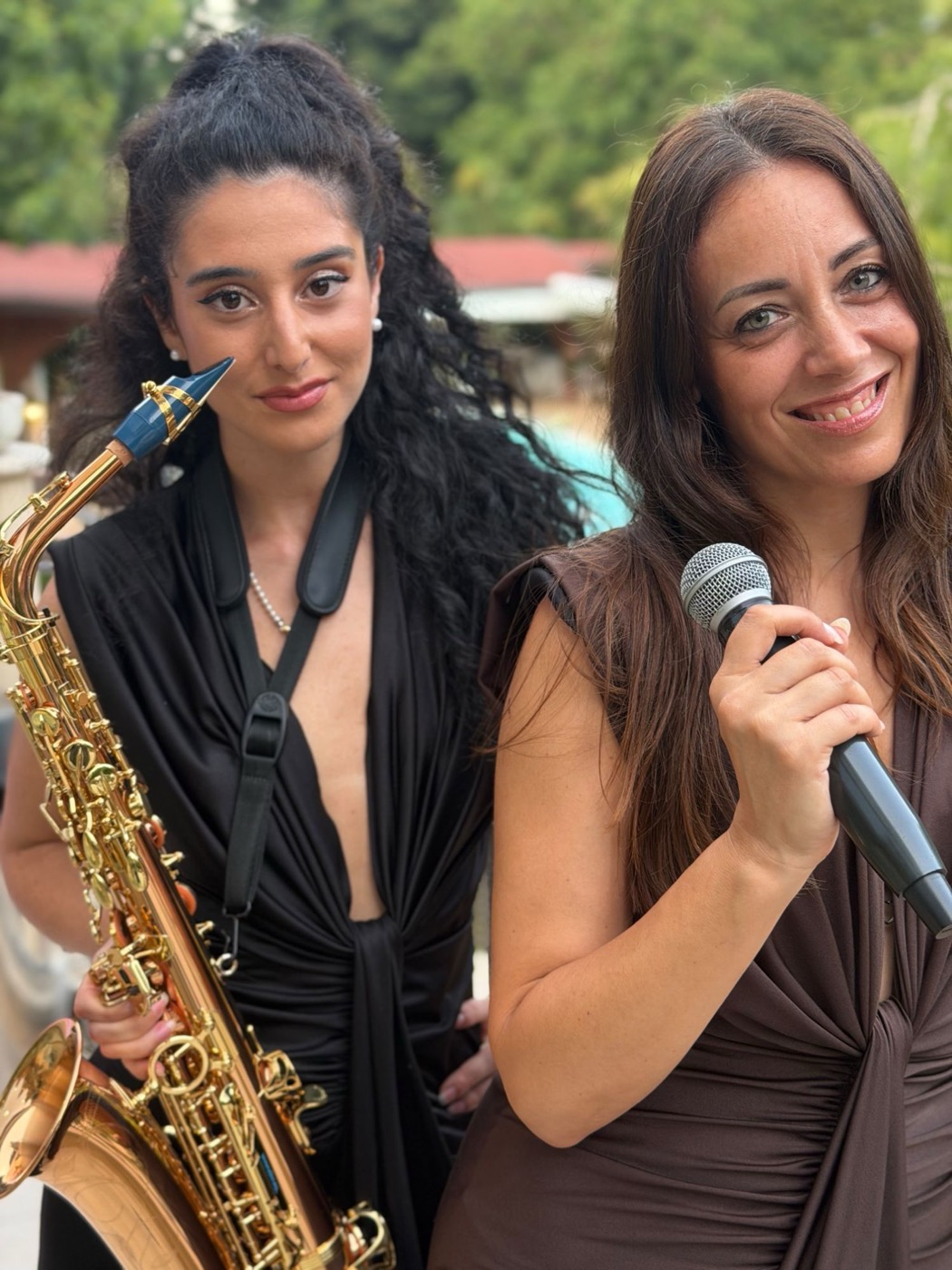 Duo sax e voce: sassofonista e cantante in abito scuro all'aperto
