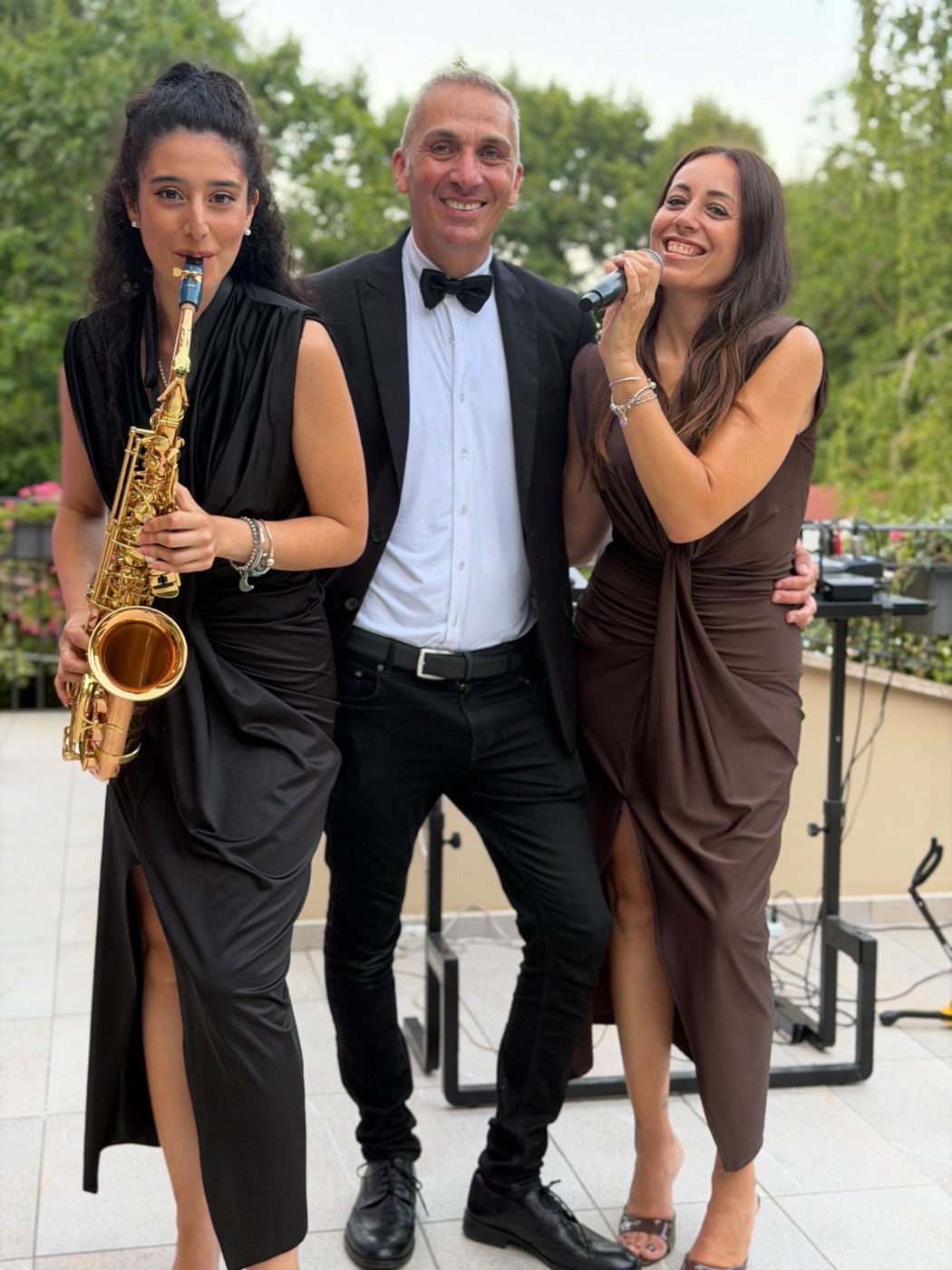 Sassofonista, cantante e musicista sorridenti in terrazza durante un evento