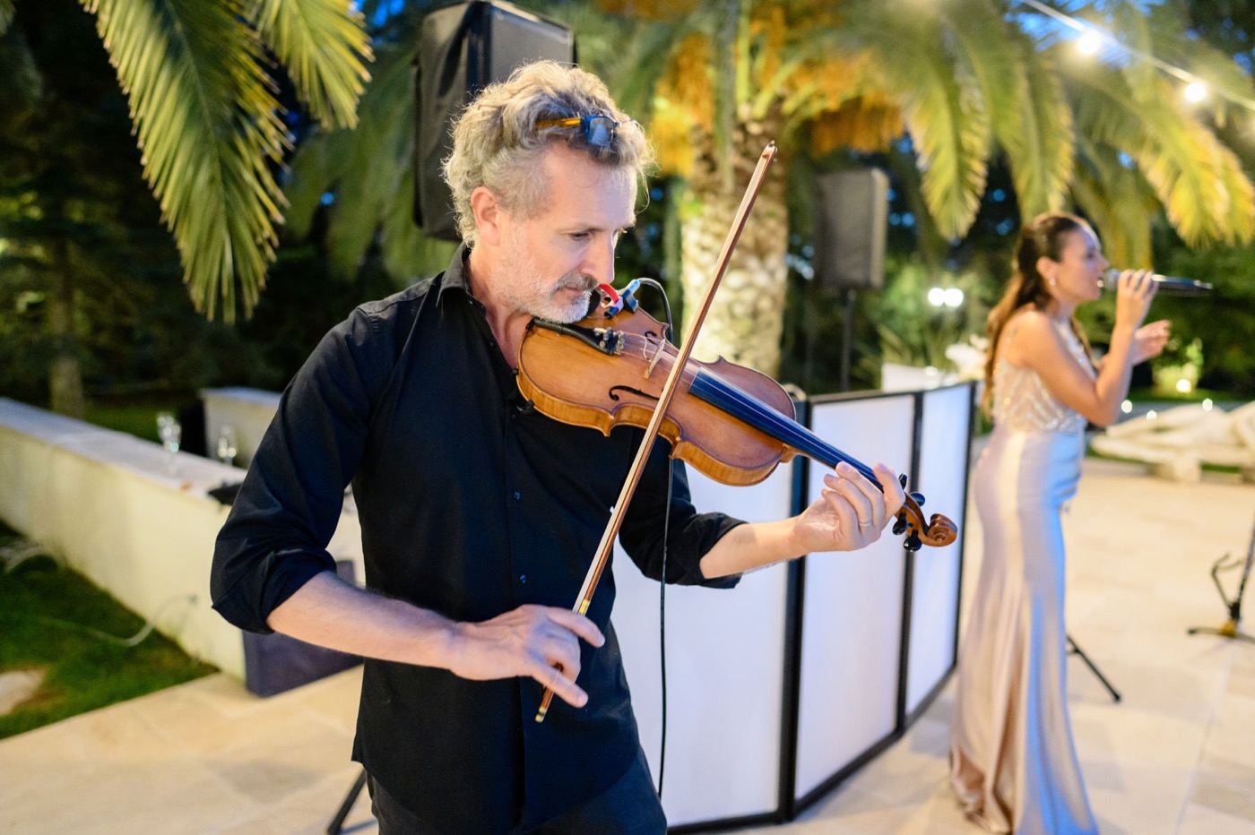 Violinista e cantante si esibiscono di sera durante un matrimonio